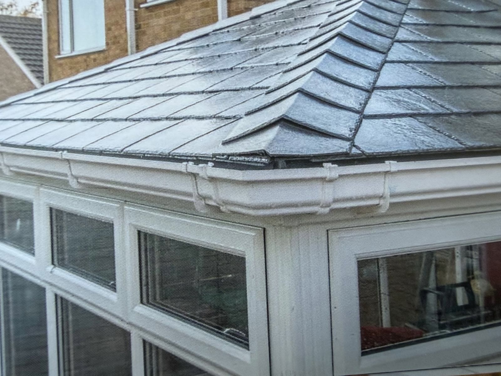 Close-up of lightweight tiled conservatory roof detailing and white frames