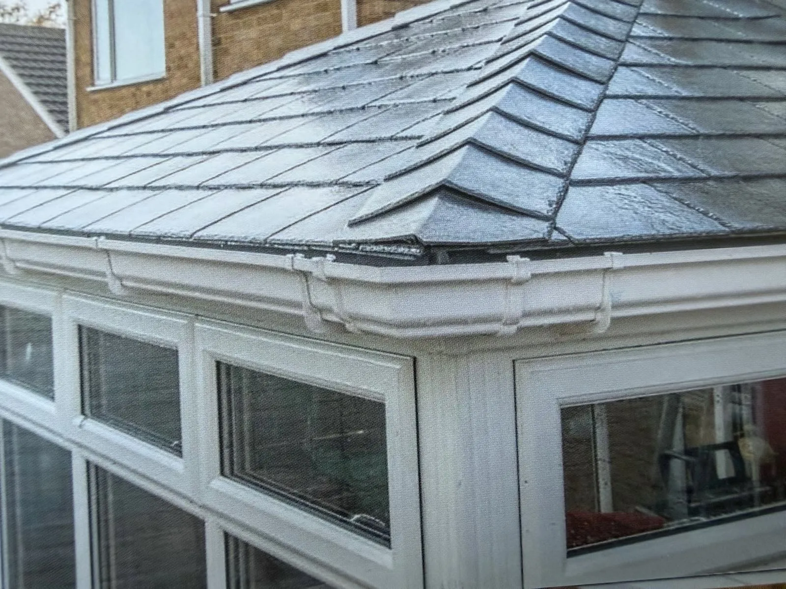 Close-up of lightweight tiled conservatory roof detailing and white frames